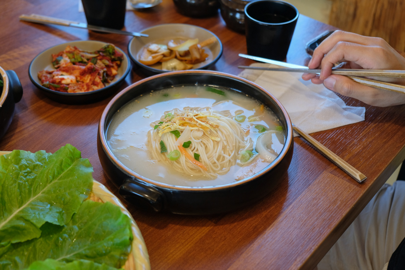 清湯黑豬肉湯麵湯頭特寫，顏色清澈但風味濃郁